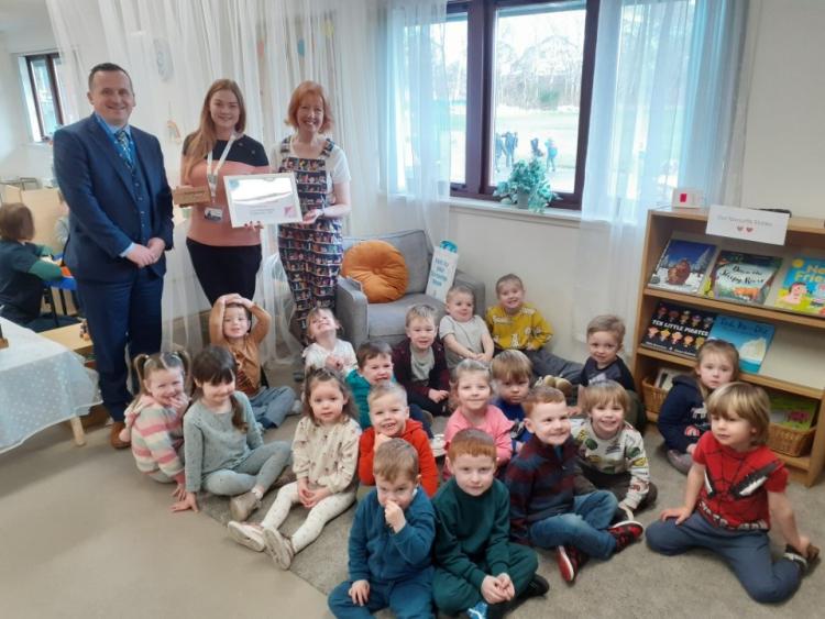 Photo of Neil Lowden, Service Leader with Angus Council visited Inverbrothock Playgroup along with Clare Fulton from Scottish Book Trust to present the award to the manager Jennifer Beattie and children. 