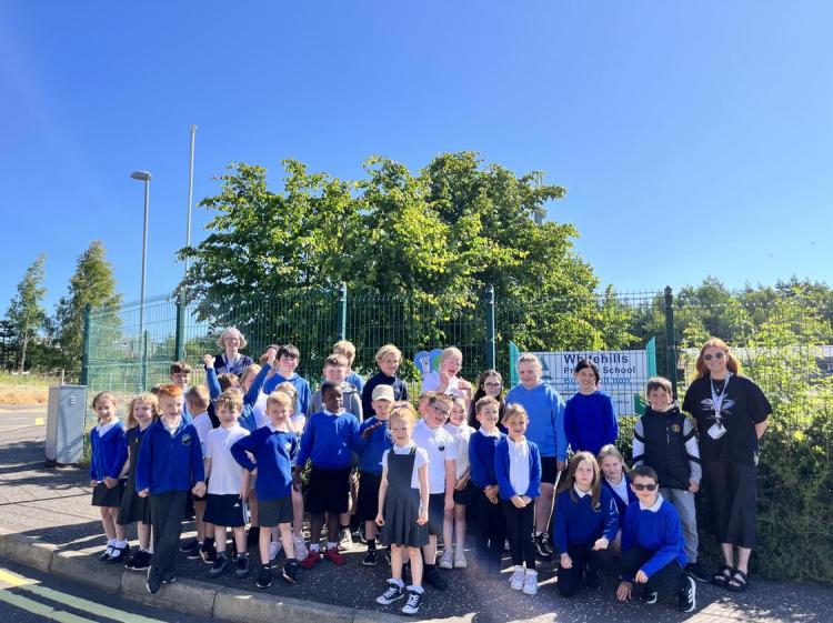 Children from P1 to P7 of Whitehills Primary School, with Head Teacher Coureeen Peters on the left and teacher Lauren Davidson on the right out side the primary school with one of the Ice Cream Trail cones the children developed for the summer holidays 